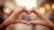 © PixMarket - Close-up of hands forming perfect heart shape against warm bokeh background