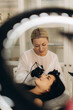 © Roman - Beautician performing permanent eyebrow makeup on woman
