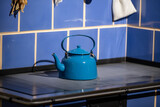 Stara kuchnia z piecem kaflowym i czajnik niebieski