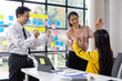 © Wasan - Diverse team celebrating a successful achievement with high-fives in office. Motivated colleagues express joy and teamwork.