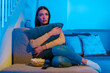 © Home-stock - Sad woman watching dramatic movie or touching old home video, sitting on couch and hugging pillow, free space