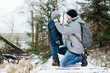 © Elena Medoks - Father caring for son in winter forest hiking trail