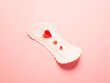 © Julllia - Sanitary pad with red paper hearts on pink background concept of menstruation and feminine hygiene