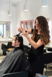 © Juanma Cuevas - Hairdresser cutting client's wet hair in salon