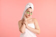 © New Africa - Woman with eye patches wrapped in towels on pink background