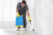 © New Africa - Pest control worker spraying insecticide in room