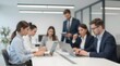 © Studicon - Blurred view of team members in modern office setting collaborating on laptops