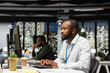 © DC Studio - Black young employee proofreading financial data for a new report at night, reviewing archived files in the strategy room. Evaluating data on reports, researching and organizing agenda.