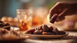 © Wahyu - Hand reaching for a date at a cozy dinner table setting, iftar in the ramadan