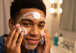 © Bakha - Gentle daily skincare routine of smiling teenage boy applying foaming cleanser to face in bathroom, practicing self care hygiene, grooming ritual and healthy skin habits before day