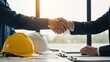 © Fajar Nuary - Two businessmen shaking hands in an office, symbolizing a successful partnership and agreement in the construction industry.