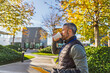 © Westend61 - Businessperson in casual attire drinking coffee with laptop outdoors in autumn