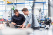 © Westend61 - Engineers discussing project on laptop in modern production hall