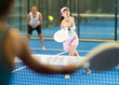 © JackF - Active woman with racket training on indoor court playing padel game and hitting ball