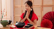 © Pixel-Shot - Young Asian woman with tea set meditating in traditional Chinese room