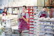 © JackF - Young female factory worker posing with finished ceramic dishes