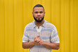 © VISTA by Westend61 - Confident man standing against yellow background with calm expression