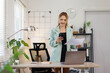 © David - Asian woman is making a phone call and writing notes in her notebook while working with financial documents and laptop at her desk in modern office