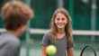 © tongpatong - A little girl and a guy are playing tennis.