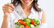 © theshooter - Close up de una mujer feliz comiendo ensalada fresca con tomate y lechuga, concepto de alimentación saludable, dieta equilibrada, hábitos de vida sana y control de peso, en fondo blanco