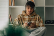 © carballo - young man with headphones and mobile phone sitting on the floor indoors