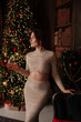 © svetograph - Elegant woman evening gown Christmas tree celebration holding glass of wine