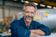 © Aillusionist - Smiling man with safety glasses working in a factory. Ideal for industrial, manufacturing, safety, and workplace related concepts and designs.