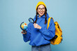 © ViDi Studio - Young overjoyed happy smart traveler woman student she wear glasses casual clothes yellow backpack bag hold globe isolated on pastel plain light blue color background. High college lifestyle concept.