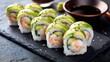 © mila103 - Fresh avocado and shrimp sushi rolls on slate with soy sauce.