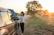 © Sirirat Makprasert - Worried Woman Calling for Roadside Assistance with Broken Down Car on Rural Road at Sunset