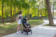 © leungchopan - Mother with baby on stroller walking forest path