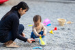© leungchopan - Mother and son playing with stones at park