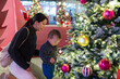 © leungchopan - Mum playing with baby near Christmas tree lights