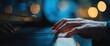 © jaya - Close-up of hands playing an instrument with illuminated keys, blurred background, & soft lighting