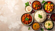 © Arafat'e - Top view flat lay of authentic Indian food feast: various curries, basmati rice, raita, and sides. Traditional Indian cuisine meal on a textured background with copy space.