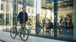 © ipolstock - Happy Caucasian Man Walking Bicycle Near Modern Office Building Facade, Sustainable Urban Business Commute