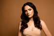 © Beauty Hero - Attractive young woman with wavy brunette hair and radiant skin in a beige dress