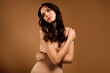 © Beauty Hero - Gentle brunette woman posing in beige outfit against monochromatic backdrop, showcasing beauty, style