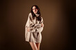 © Beauty Hero - Charming young woman in an oversized beige sweater, posing gracefully against a warm gradient background