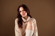 © Beauty Hero - Portrait of a young woman in a beige sweater against a neutral background, emphasizing elegance, fashion