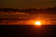 © AmazingAerialAgency - Aerial view of the sun dips below the horizon, painting the sky with fiery hues above the dark sea, Alicante, Valencian Community, Spain.