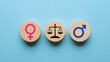 © Imro Stock - Gender equality concept with scales of justice between male and female symbols on blue background. Equal rights, workplace fairness, balance, illustration.