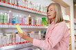 © zinkevych - Blonde good-looking mature woman in a drug store choosing something