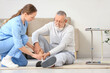 © Pixel-Shot - Nurse and injured senior man after fall with walker at home