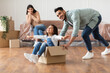 © Prostock-studio - Playful family of three people having fun in their new apartment on relocation day. Happy bearded man and his daughter playing together with carton box while moving, girl spreading hands