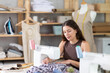 © JackF - Skillful young tailoress sewing textile sitting at her workplace in tailor shop