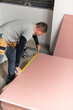 © Milles Team/Stocksy - Builder measuring drywall