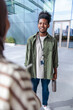© Jovo Jovanovic/Stocksy - Young professional smiles, holding water bottle, wearing ID badge.