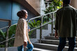 © Jovo Jovanovic/Stocksy - Two people walk up stairs in a modern building.