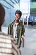 © Jovo Jovanovic/Stocksy - Smiling man with water bottle and ID badge outdoors.